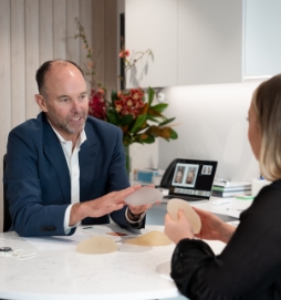 Dr Hunt with a female patient presenting breast implants, breast surgery consultation